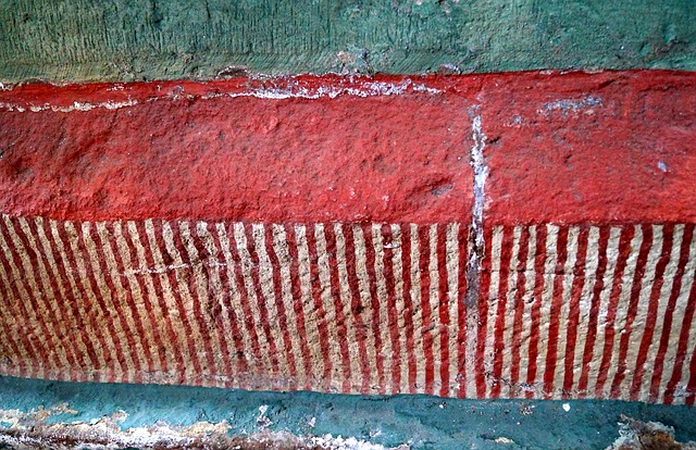 blue red striped art deteriorating on wall
